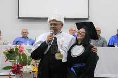 O Reitor Wally Menezes abraça a formanda Emily durante seu discurso